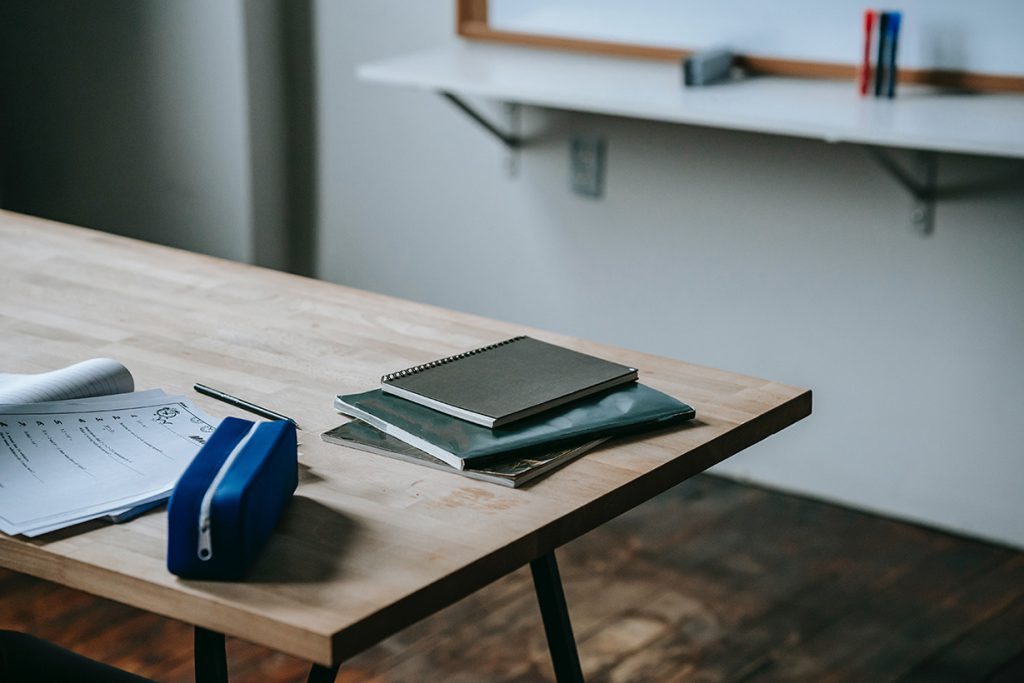 desk with journal on top and pencil pouch